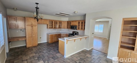 A kitchen with wooden cabinets and a tiled floor.