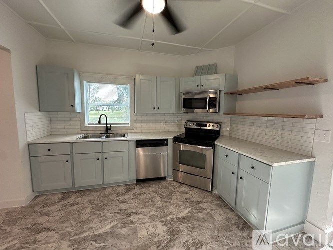 A kitchen with a fan and a window.