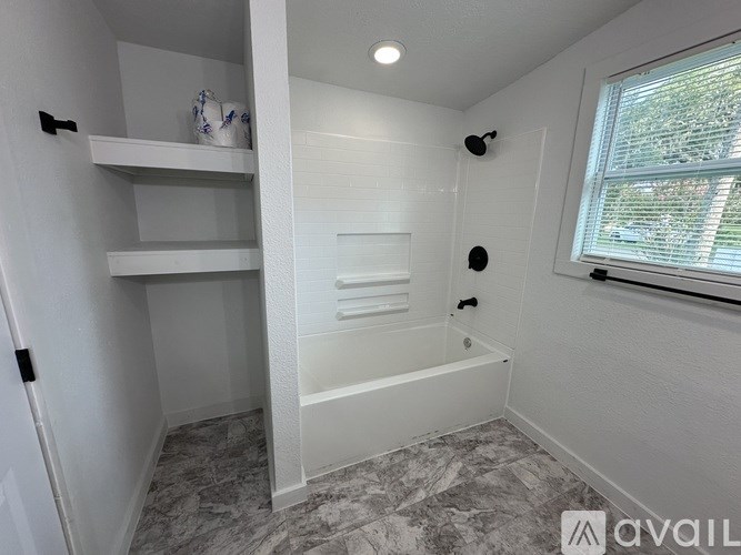 A room with a ceiling fan and wooden flooring.