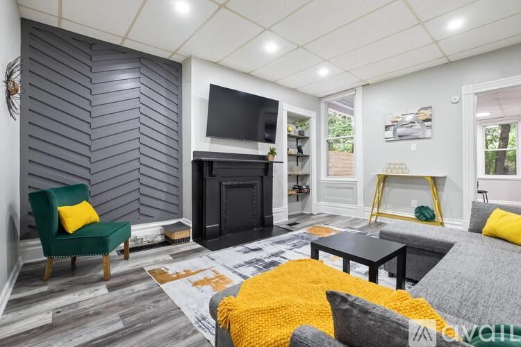 A living room with a fireplace and a green chair.