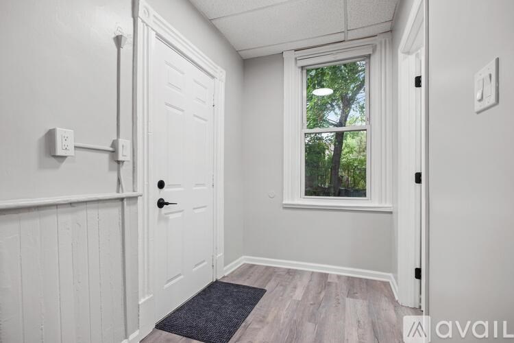 A white door with a black handle is on the left side of the image.