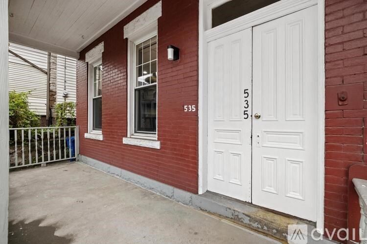 A red brick house with a white door and window.