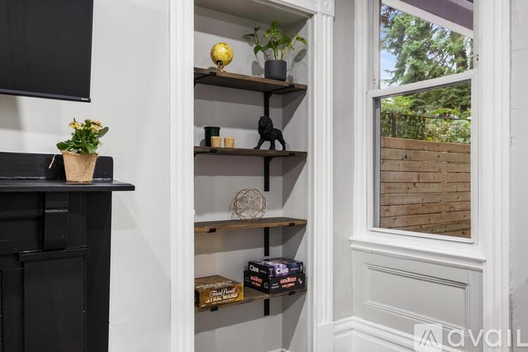A black fireplace with a plant on top and a shelf with various items.