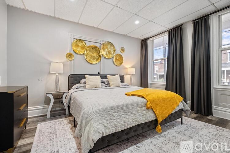 A bedroom with a large bed and a yellow throw blanket.