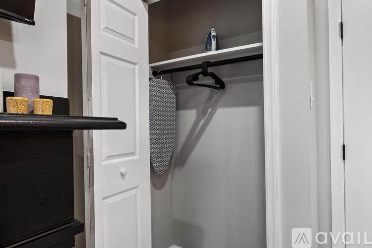 A white door is open to reveal a black shelf with candles and a purple candle holder.