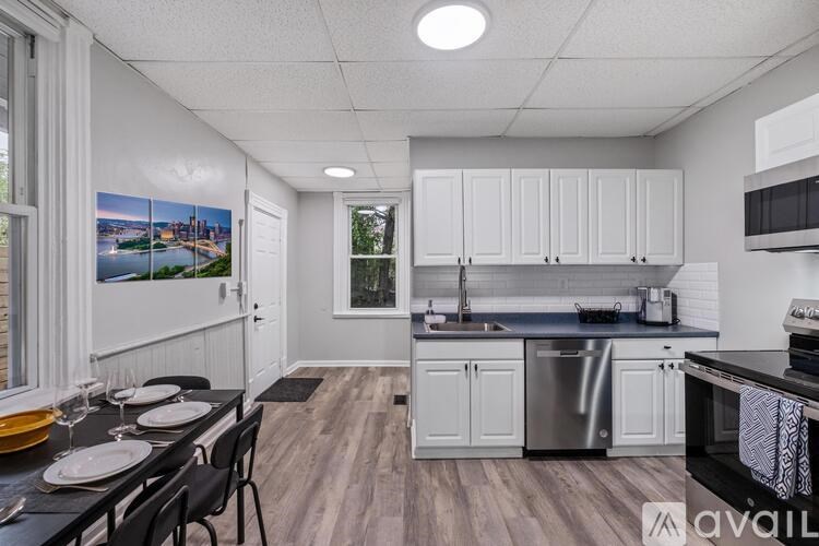 A kitchen with white cabinets and a black countertop.