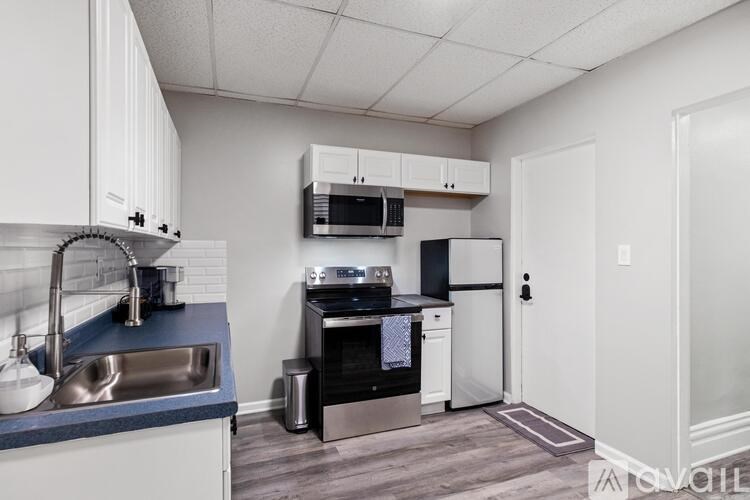 A kitchen with a stainless steel sink and a microwave above it.