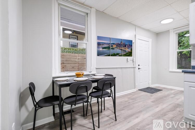A dining room with a table and chairs.