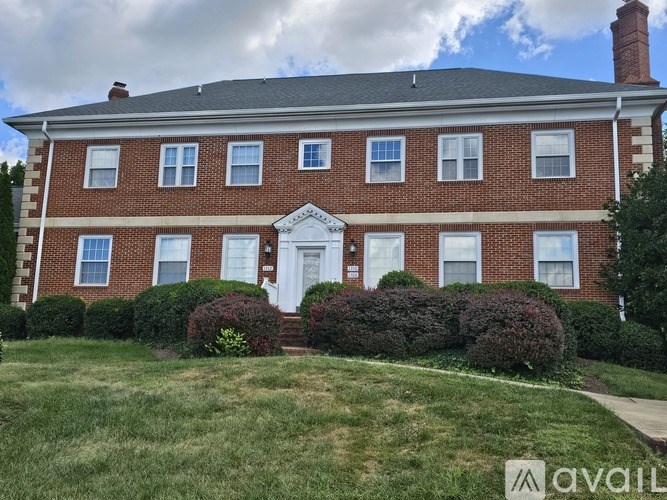 A red brick house with a white door and windows.