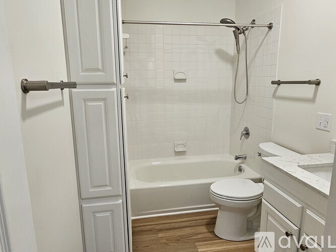 A white bathroom with a toilet, sink, and bathtub.