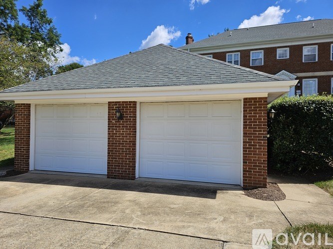 A two-car garage with a brick pillar and a grey roof.