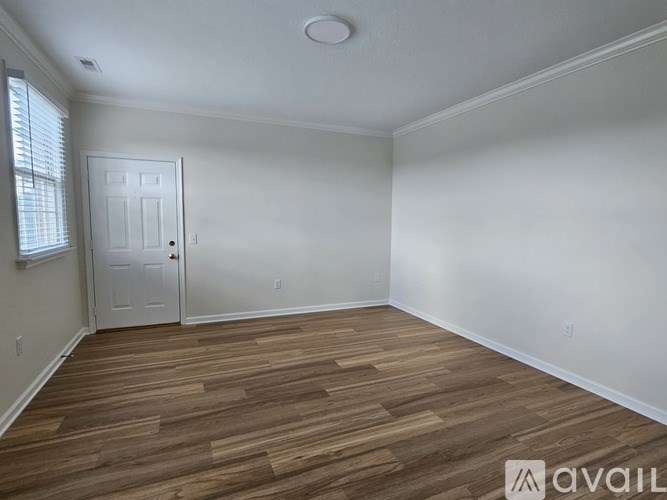 A room with wooden flooring and a white door.