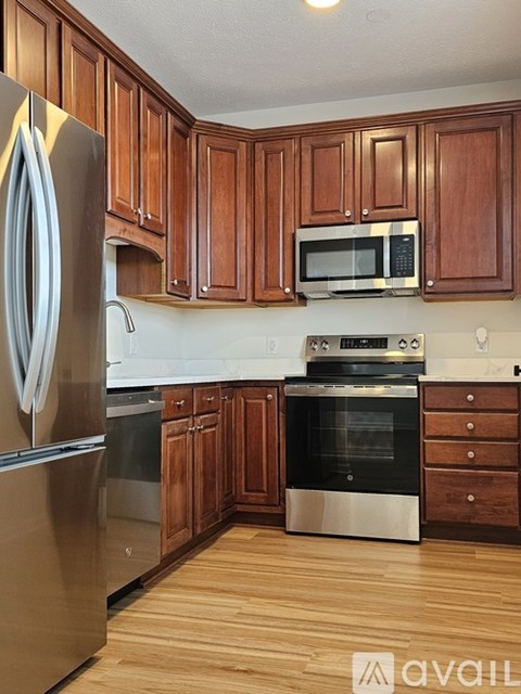 A kitchen with wooden cabinets and stainless steel appliances.