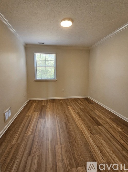 A room with wooden flooring and a window.