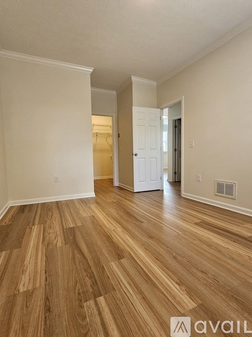 A room with wooden flooring and white walls.