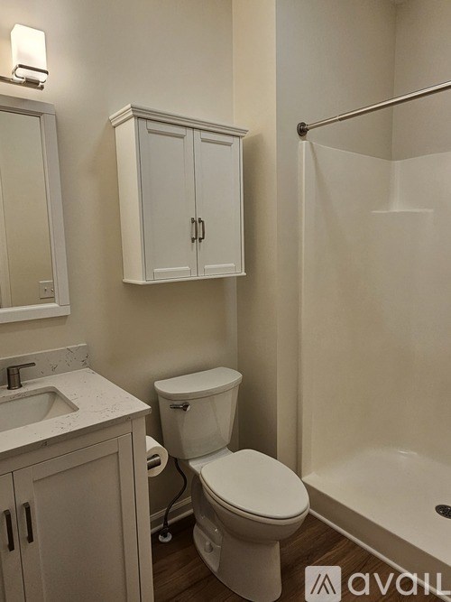 A white toilet sits in a bathroom next to a sink and a shower.