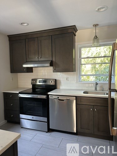 A kitchen with dark brown cabinets and stainless steel appliances.