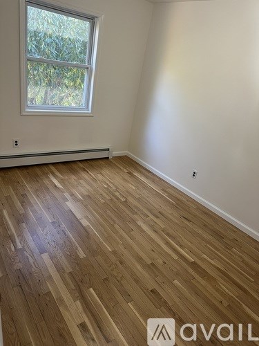 A room with wooden flooring and a window.
