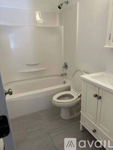 A white bathroom with a toilet, sink, and bathtub.