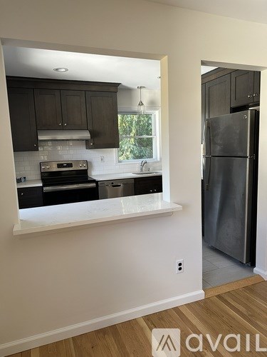 A kitchen with a refrigerator and a window.