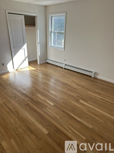A room with wooden flooring and a window.