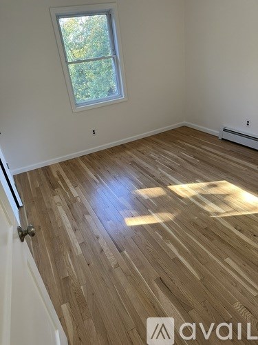 A room with wooden flooring and a window.