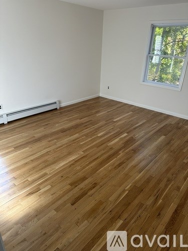 A room with wooden flooring and a window.