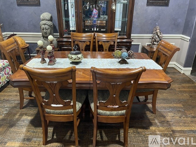 A wooden dining table with chairs and decorative items on top.