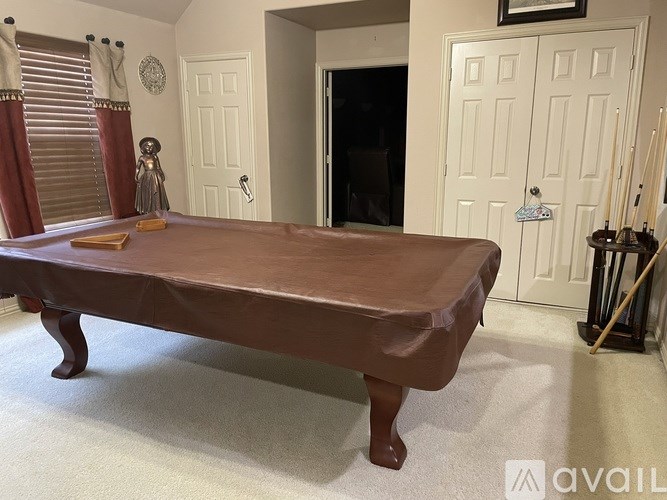 A bed with a brown cover is in a room with white walls.