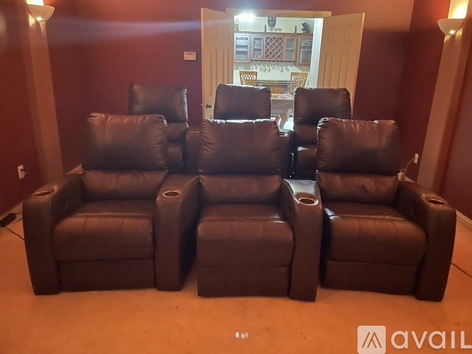A set of brown leather reclining sofas are arranged in a row.