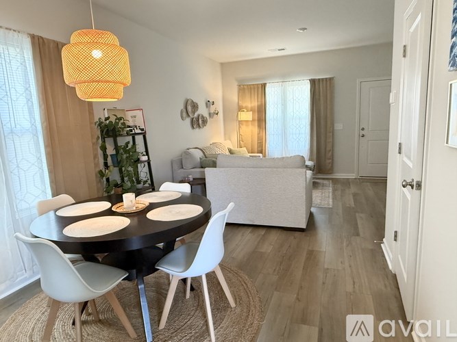 A modern dining room with a round table and white chairs.