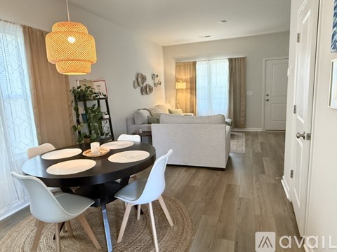 A modern dining room with a round table and white chairs.