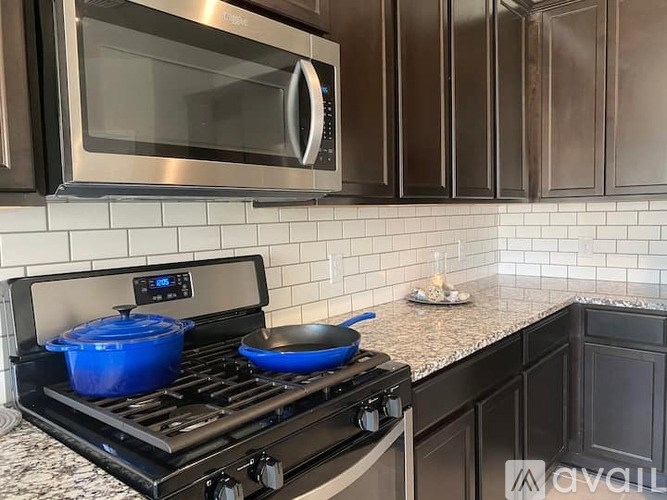 A modern kitchen with a black stove top oven and a black microwave above it.