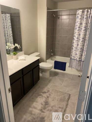 A bathroom with a toilet, sink, and shower.