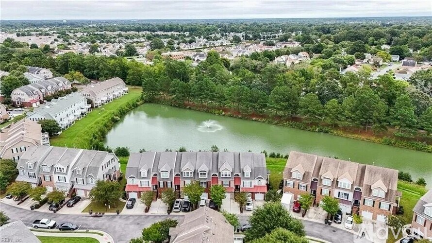 A bird's eye view of a residential area with a lake in the middle.