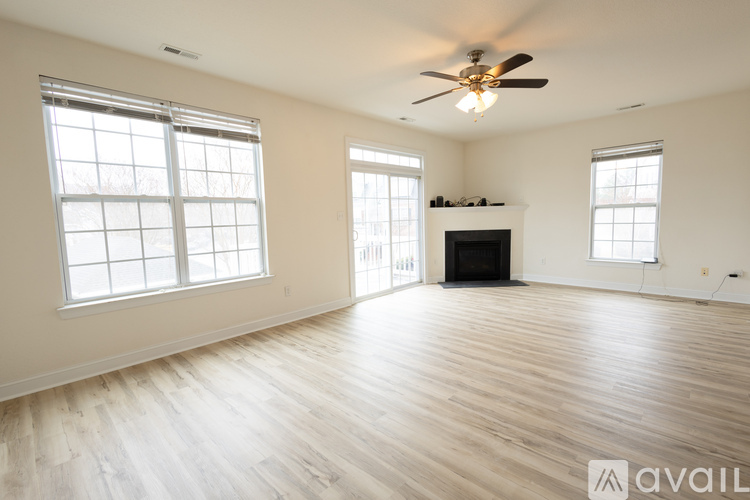 A spacious living room with a fireplace and hardwood floors.