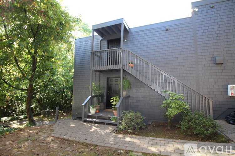A small balcony with a railing is on the side of a grey building.