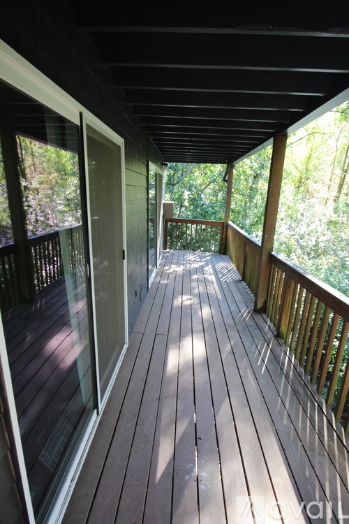 A wooden deck with a railing and a glass door.