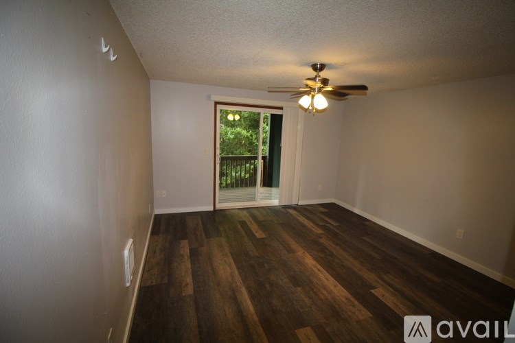 A room with wooden floors and a ceiling fan.