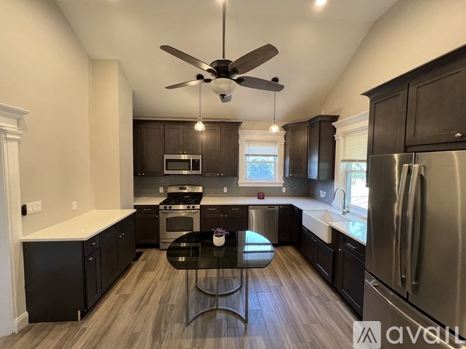 A kitchen with dark wood cabinets and a black table.