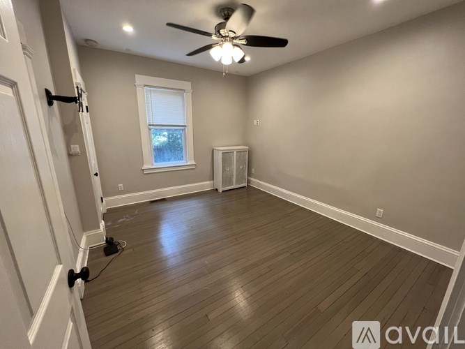A room with a ceiling fan and a window.