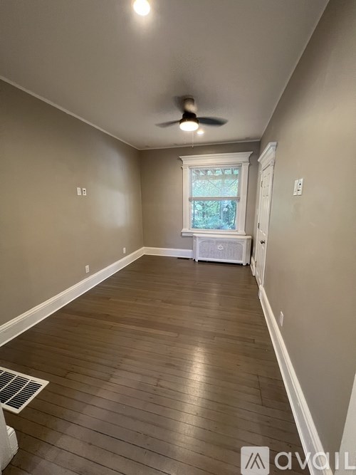 A room with wooden flooring and a ceiling fan.