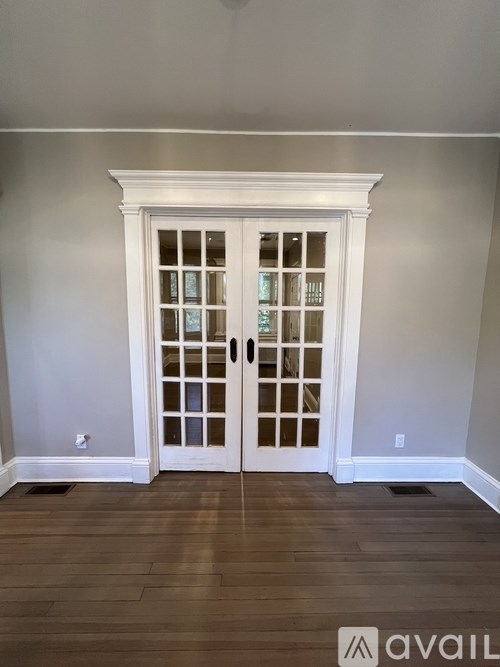 A white double door with glass panels and a transom window above it.