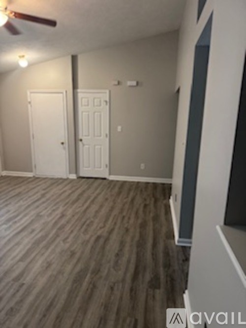 A room with wood flooring and two white doors.