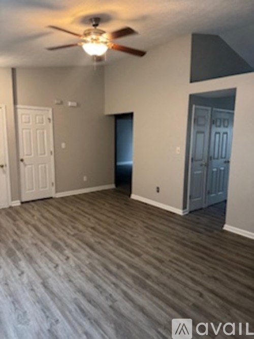 A room with a ceiling fan and two doors.