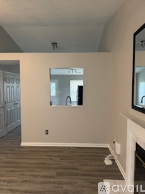 A room with a fireplace and a mirror on the wall.