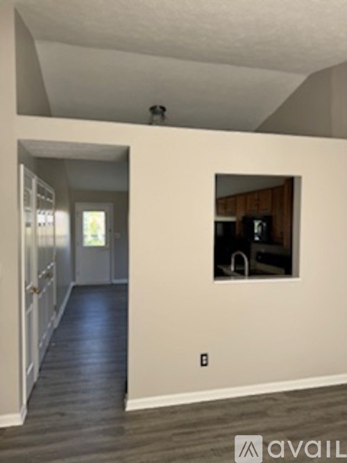 A room with a window and a door leading to another room.