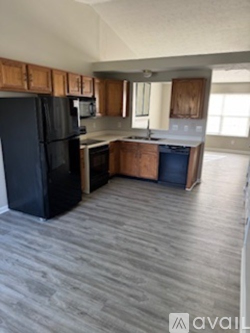 A kitchen with black appliances and wooden cabinets.
