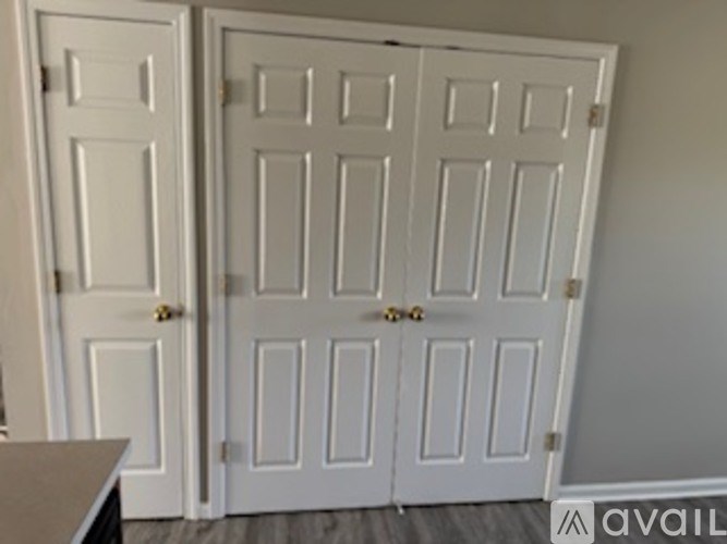 A white double door with a gold handle is closed.