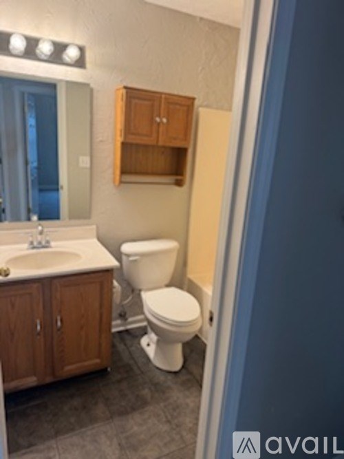 A bathroom with a toilet, sink, and medicine cabinet.